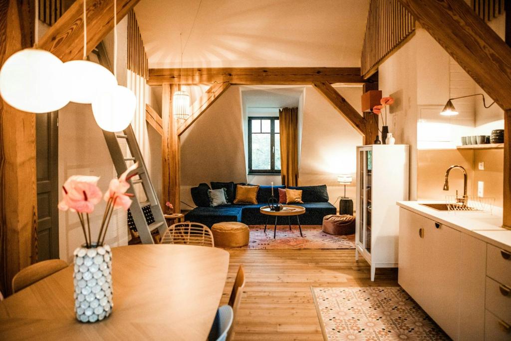 Una cocina y una sala de estar con un sofá azul. en Designer Apartment In Historic Pond House, en Freudenfeld
