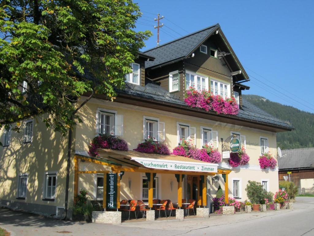 ein Gebäude mit Blumen auf der Seite in der Unterkunft Gasthof Zauchenwirt in Bad Mitterndorf