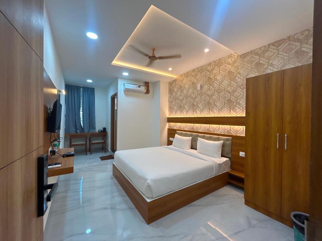 a bedroom with a bed and a television in it at Hotel O Golden Stay in Bengaluru