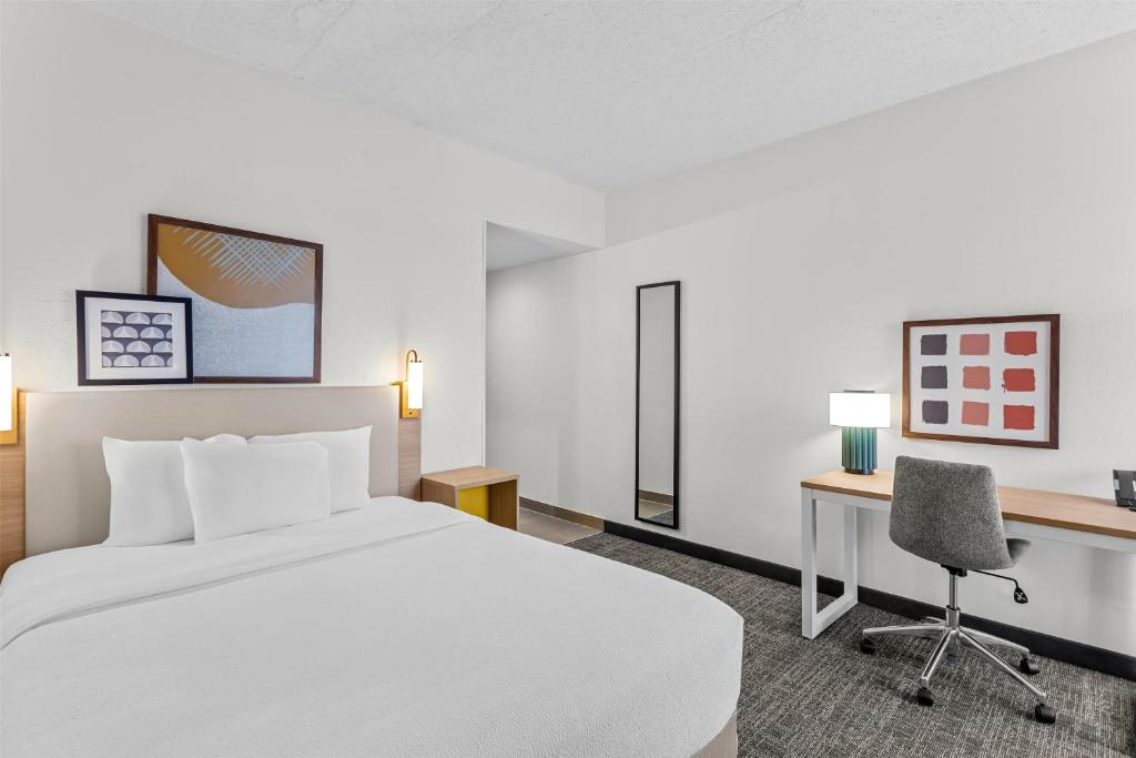 a hotel room with a bed and a desk at Spark by Hilton Des Plaines Chicago O'Hare in Des Plaines