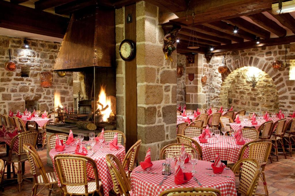 a dining room with tables with red napkins on them at Auberge Saint Pierre in Le Mont Saint Michel