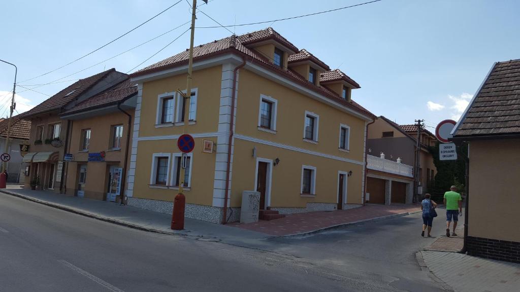a yellow building on the side of a street at Penzión Galéria in Bojnice
