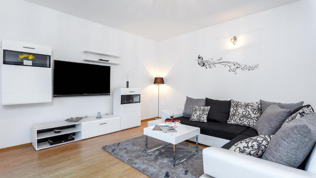 ein Wohnzimmer mit einem Sofa und einem TV in der Unterkunft Holiday Home Iris in Marina