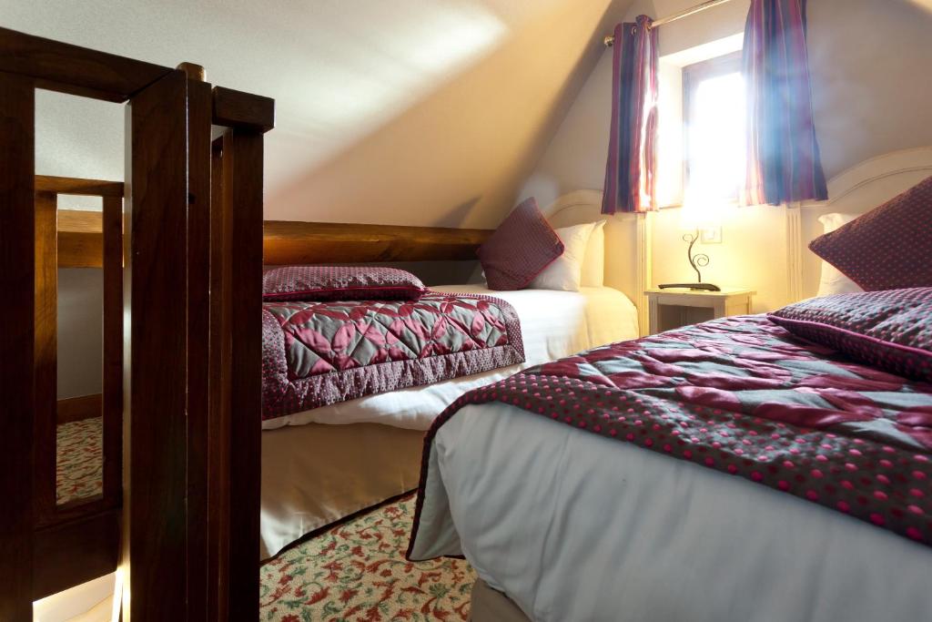 a bedroom with two beds and a window at Auberge Saint Pierre in Le Mont Saint Michel