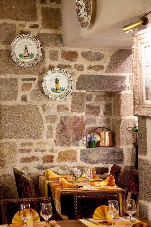 a dining room with tables and plates on the wall at Auberge Saint Pierre in Le Mont Saint Michel