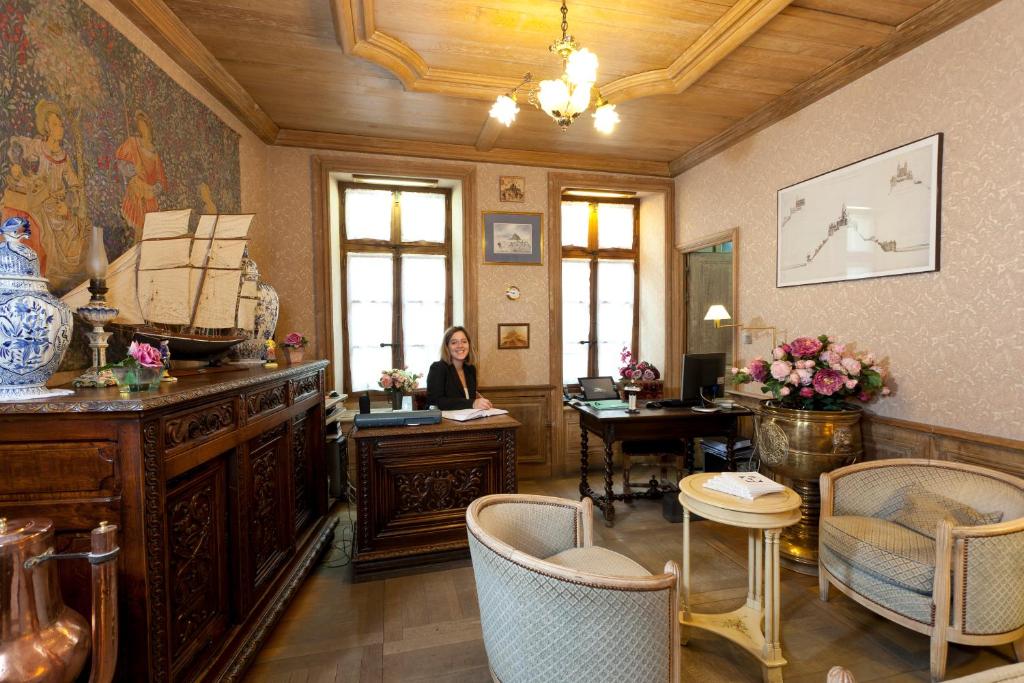 a woman sitting at a desk in a room at Auberge Saint Pierre in Le Mont Saint Michel