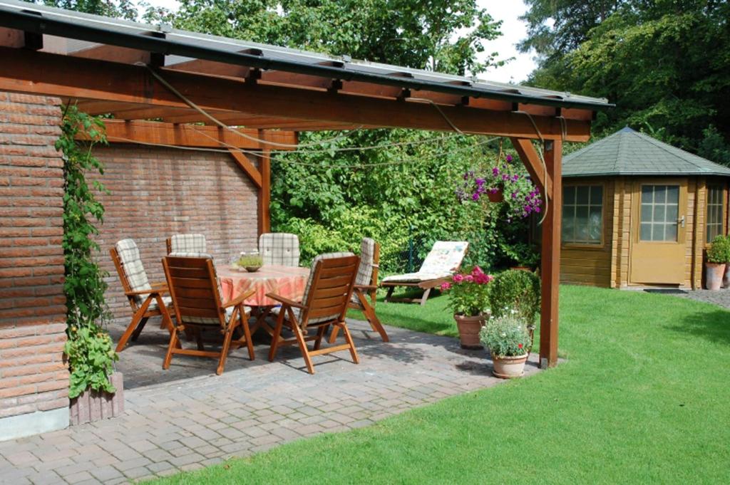 een patio met een tafel en stoelen onder een pergola bij Aaltine 2 in Bad Bentheim