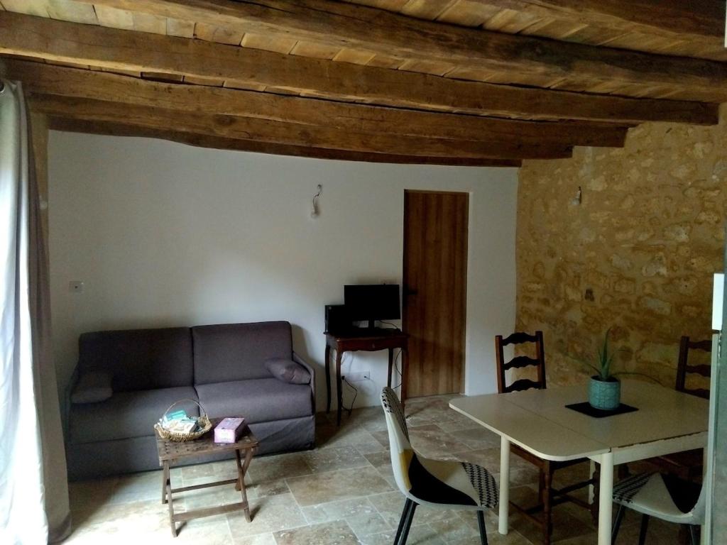a living room with a couch and a table at Chez Anaïs in Cénac-et-Saint-Julien