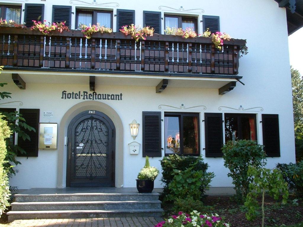 ein Gebäude mit einem Balkon, einer Tür und Blumen in der Unterkunft Hotel Schweizer Haus in Bielefeld