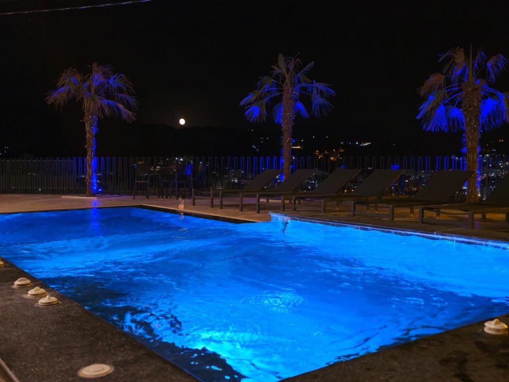a swimming pool at night with palm trees at Hotel Selavi in Sarandë