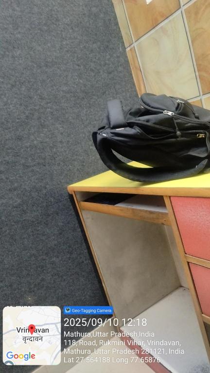 una borsa nera appoggiata sopra uno scaffale di Hotel samarth a Vrindāvan