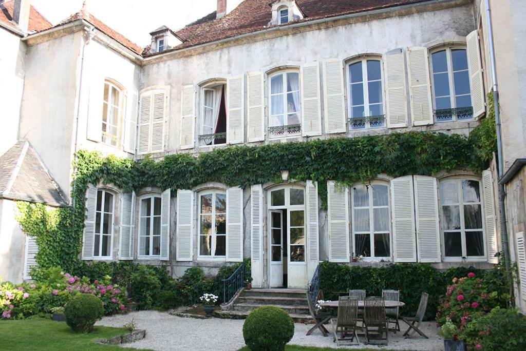 una gran casa blanca con hiedra creciendo en ella en B&B Le Jardin de Carco, en Châtillon-sur-Seine