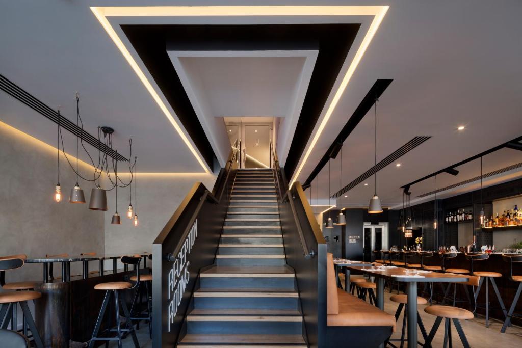 a staircase leading up to a restaurant with tables and chairs at Ultra Tel Aviv Boutique Hotel in Tel Aviv