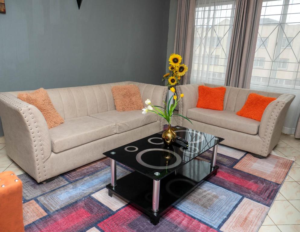 una sala de estar con un sofá y una mesa en Perfect Palm Condos-F16, en Nakuru
