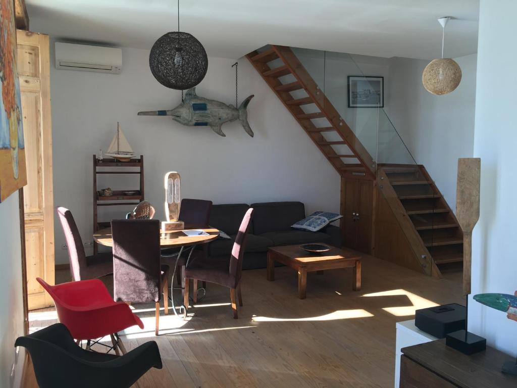 a living room with a staircase and a table and chairs at Marina Apts. Vila Real in Vila Real de Santo António