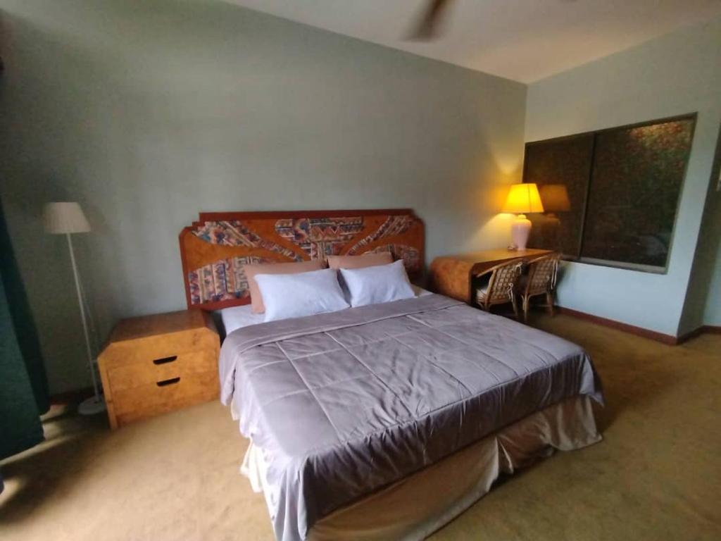 ゲンティンハイランドにあるHomestay at AWANA GENTING HIGH LANDSのベッドルーム(ベッド1台、テーブル、ランプ付)