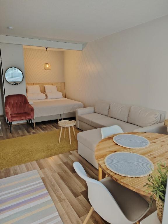 a living room with a couch and a table at Rauhallinen majoitus parvekkeella in Joensuu
