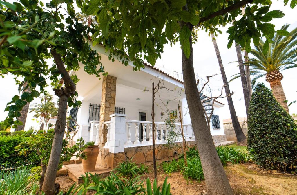 a white house with trees in front of it at Villa Beatriz in Benicarló