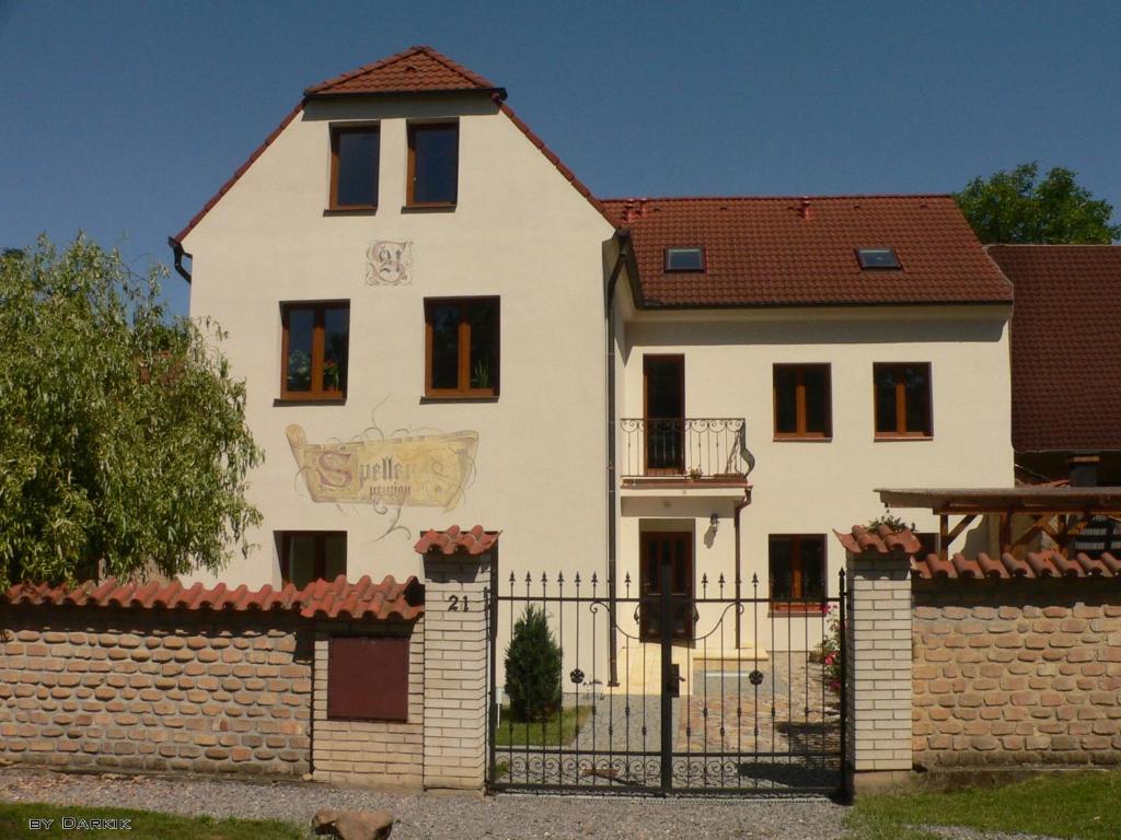 a white house with a gate and a fence at Penzion Speller in Vysoký Újezd