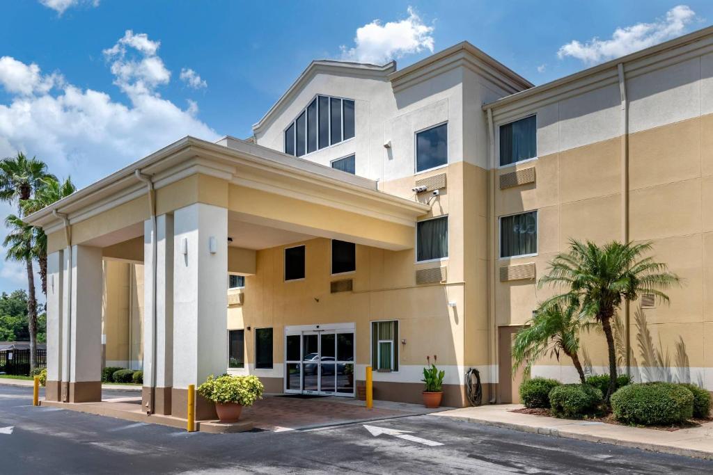 Un gran edificio con palmeras delante. en Comfort Inn &amp; Suites DeLand - near University, en De Land
