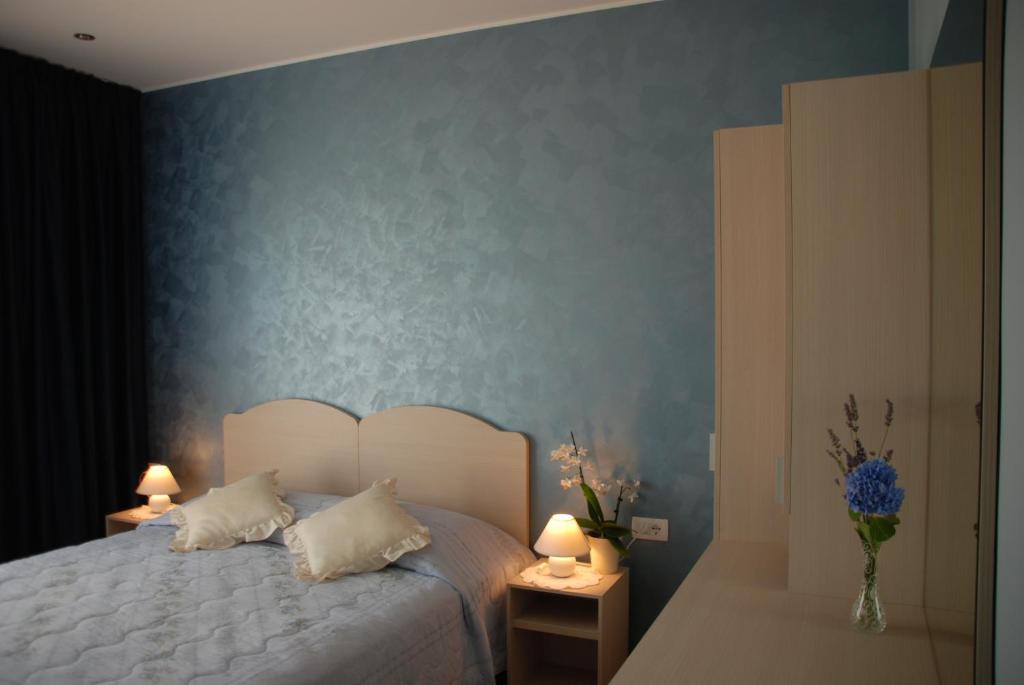 a bedroom with a bed with a blue wall at Rooms Edda in Umag