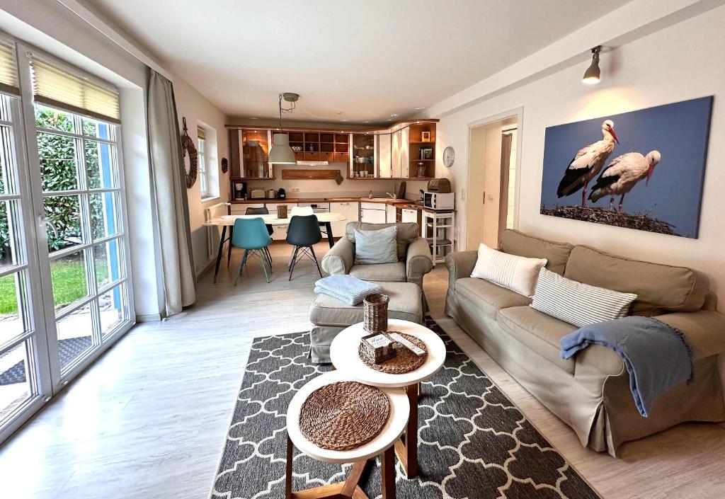a living room with a couch and a table at Cozy Wohnung fuer 4 Gaeste mit Terrasse unter Reet in Sankt Peter-Ording