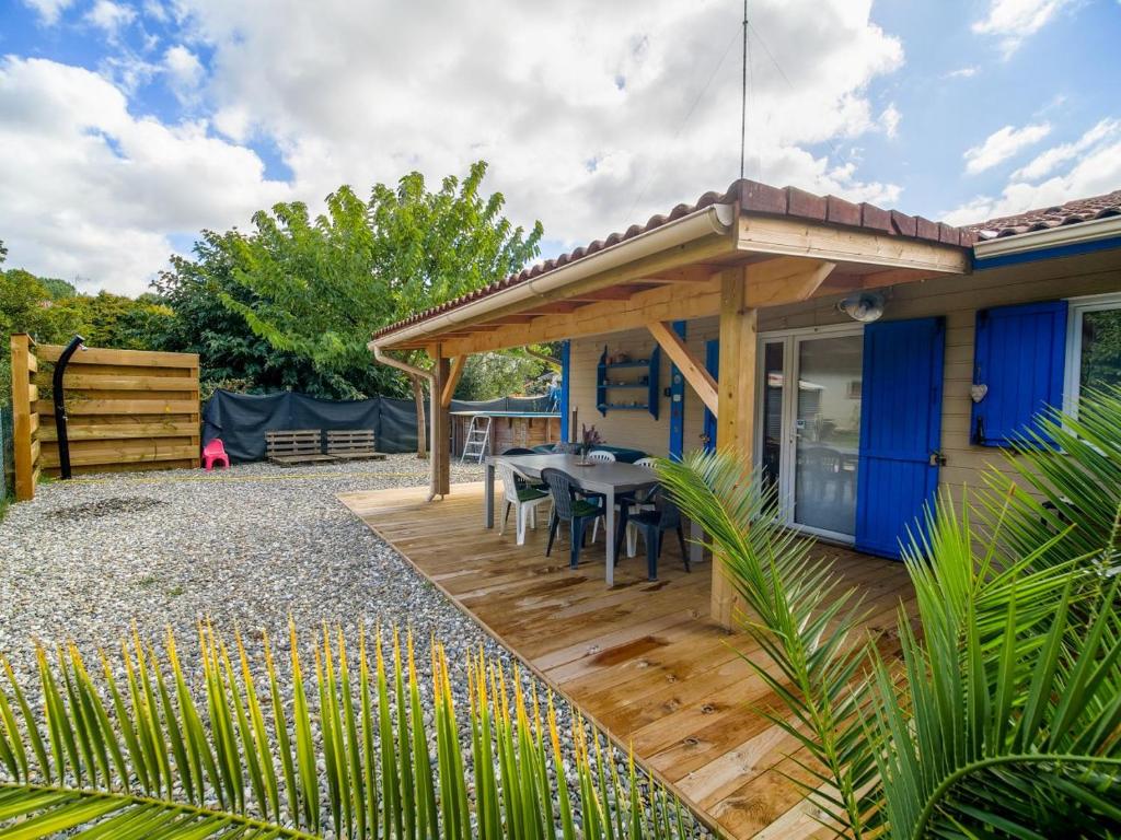 a house with a wooden deck with a table at Jolie Cabane Océan in Vielle-Saint-Girons