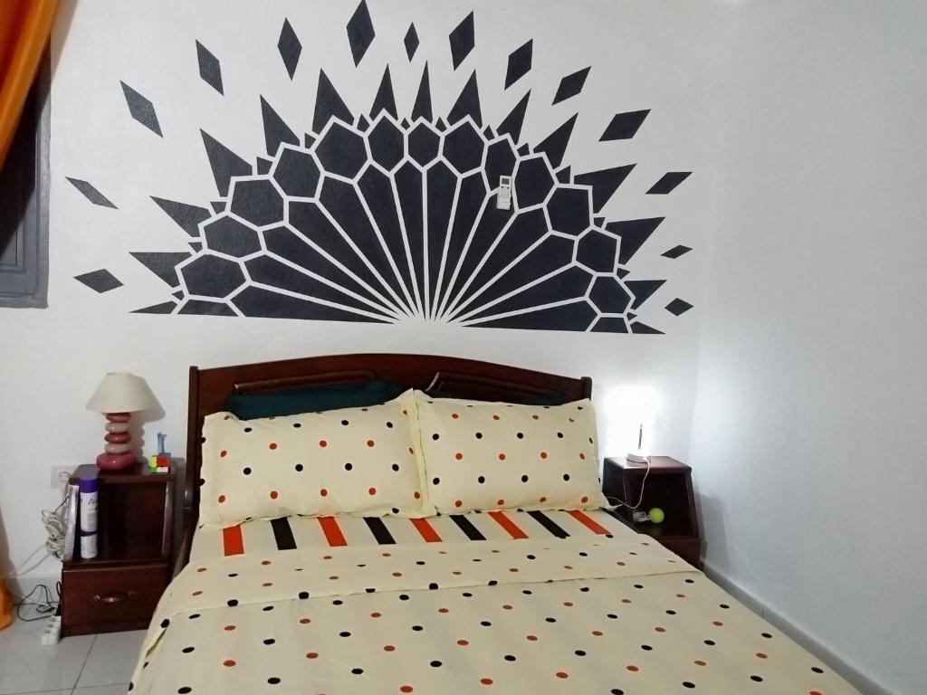 a bedroom with a bed with a large painting on the wall at Iroko Plage San Pédro in San-Pédro