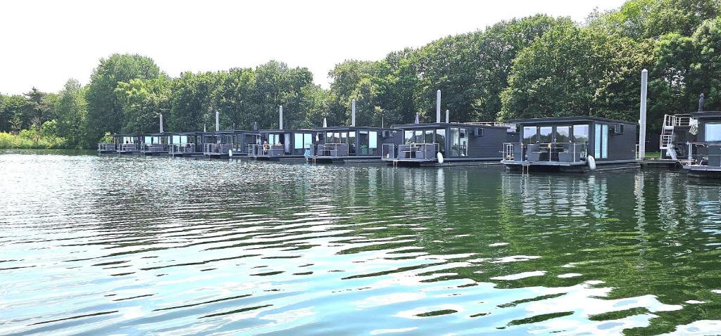 a row of houses on a dock on a body of water at Houseboat Marina Mookerplas on the Water | 4 - 6 people in Middelaar