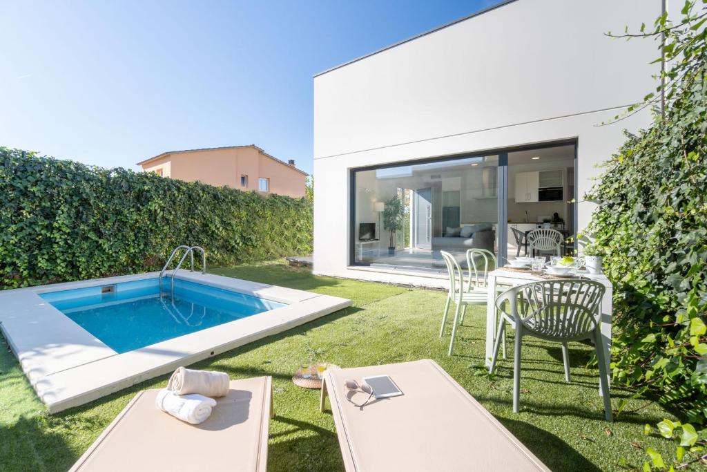 a backyard with a swimming pool and a table and chairs at Jouvacations Villa Sol La Selva in Vilafant