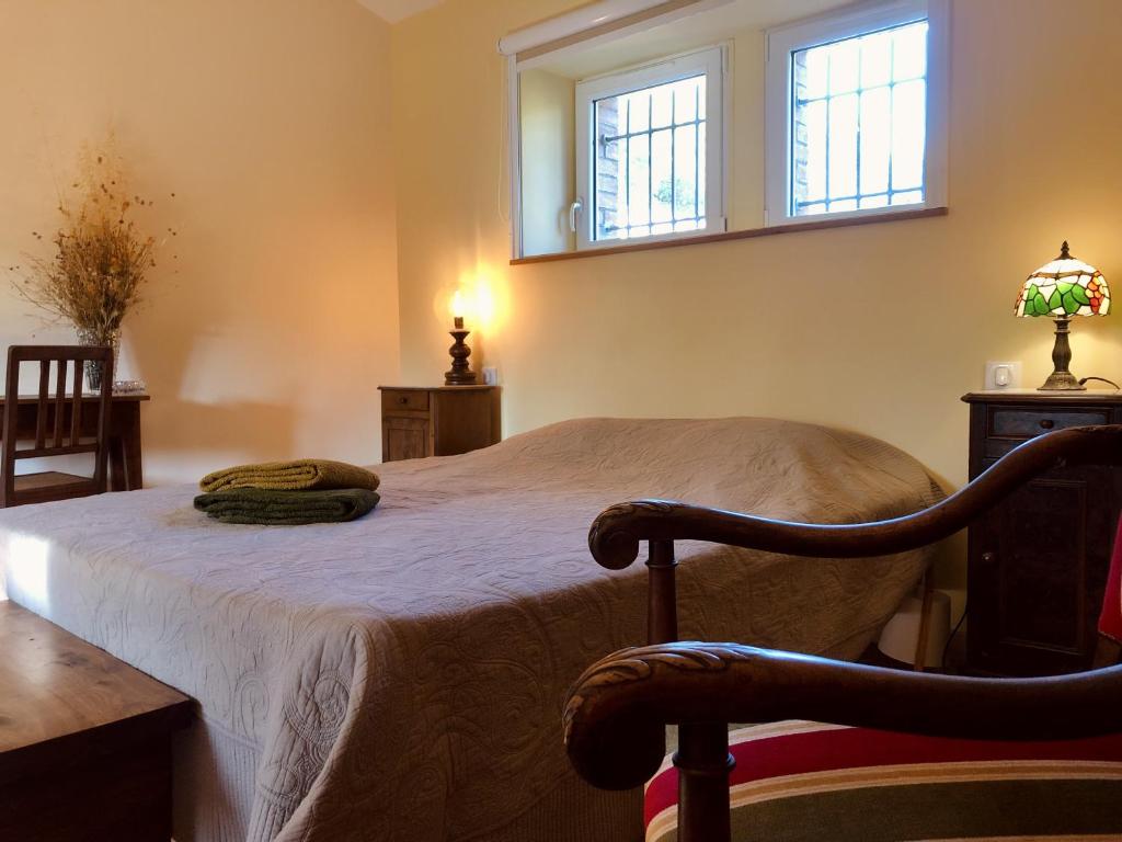 Saint-Julien-de-CassagnasにあるLou moulinouのベッドと2つの窓がある寝室