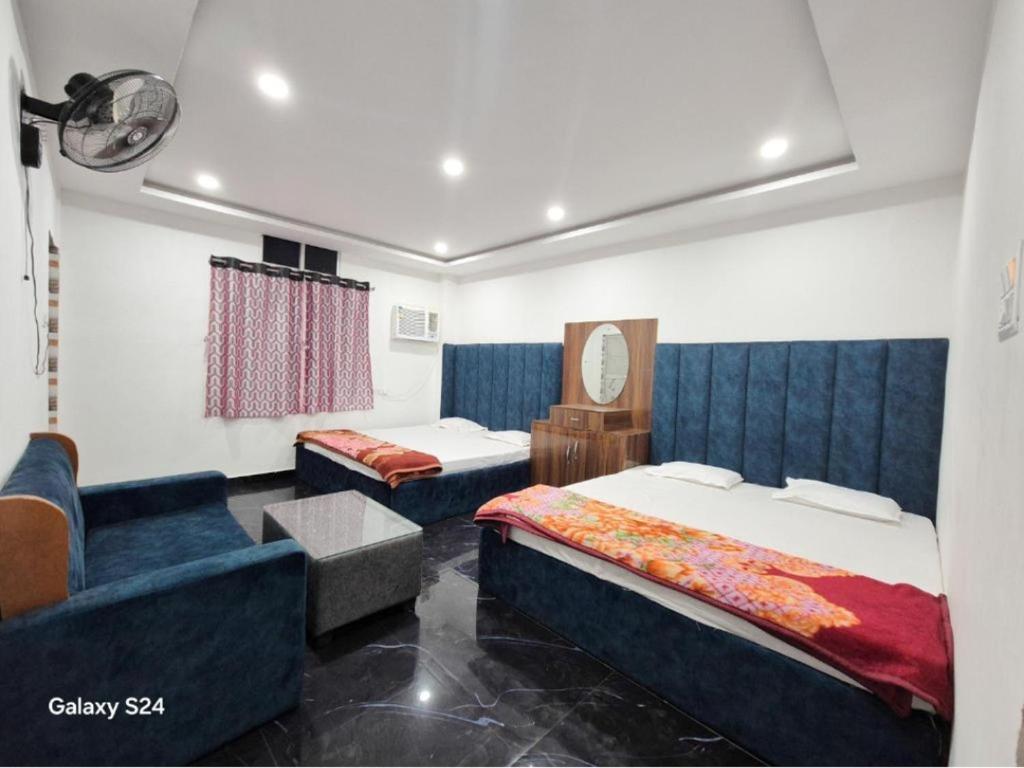 a hotel room with two beds and a couch at Hotel Parinay Vatika - Deoghar in Deoghar