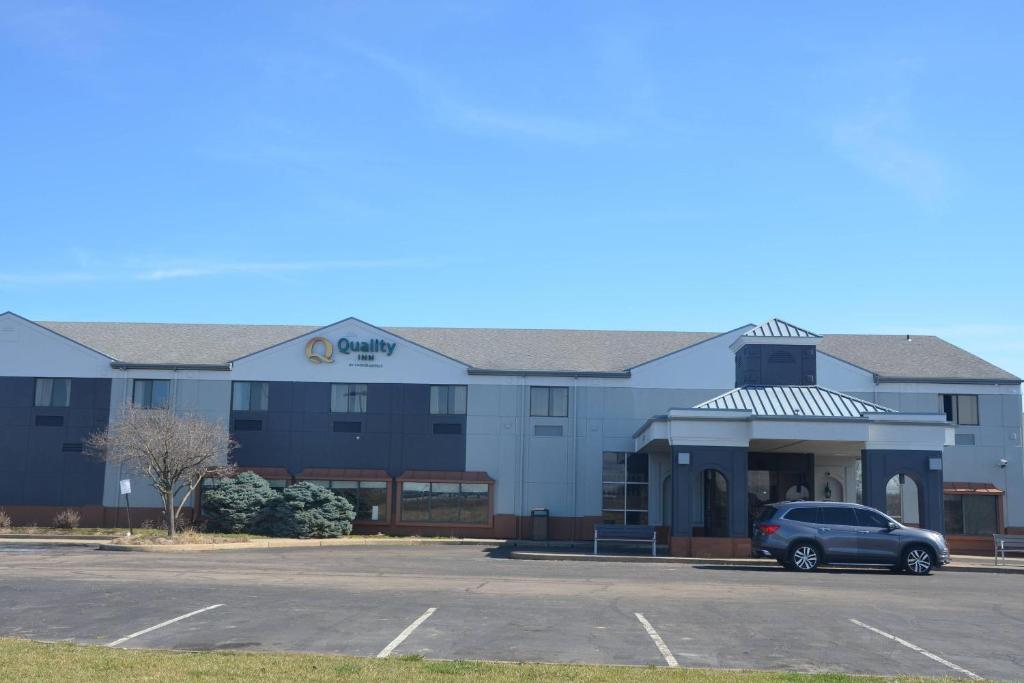 a building with a car parked in a parking lot at Quality Inn in Perrysburg