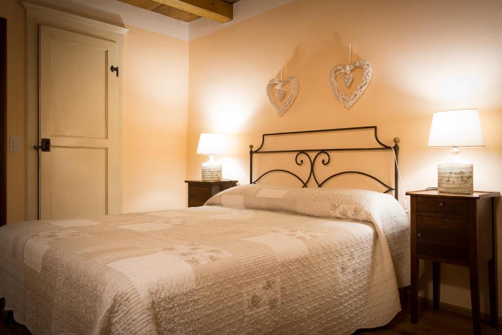 1 dormitorio con 1 cama y 2 corazones en la pared en Da Titta en Pitigliano