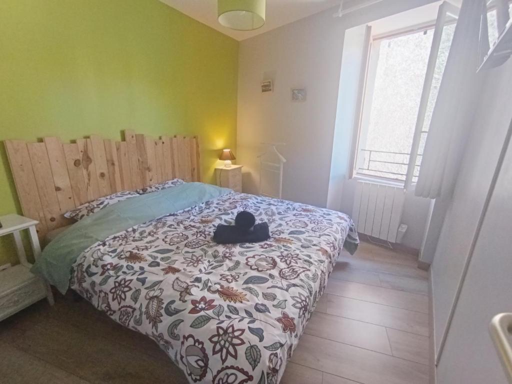 a bedroom with a bed with a stuffed animal on it at Le Nid du Haut in Saint-Nectaire