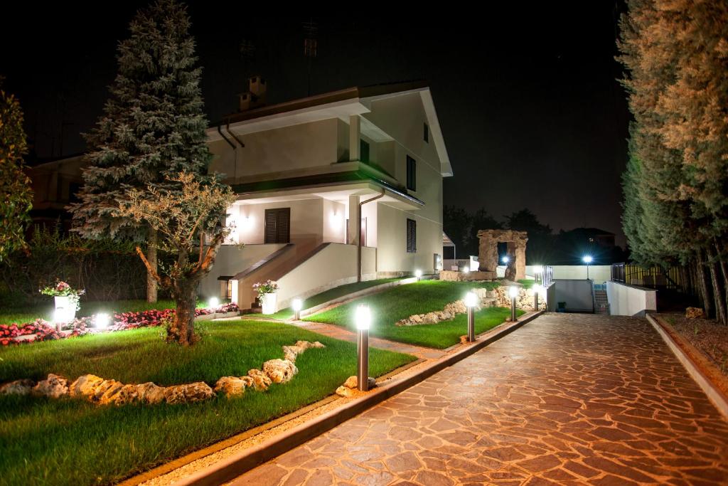 a house at night with lights on the driveway at B&B Villa Aurora in Brugherio