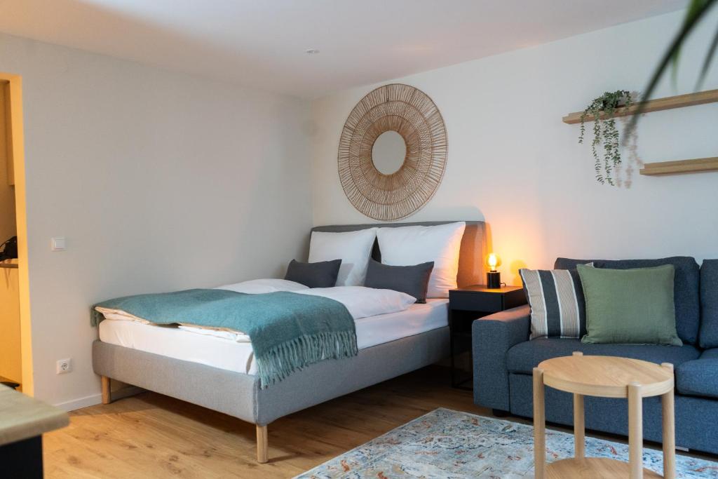 a bedroom with a bed and a blue couch at Renovated Munich City Center Apartment near Oktoberfest in Munich