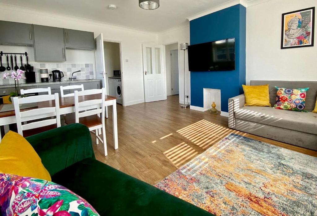 a living room with a couch and a kitchen at Cairo House in Peacehaven