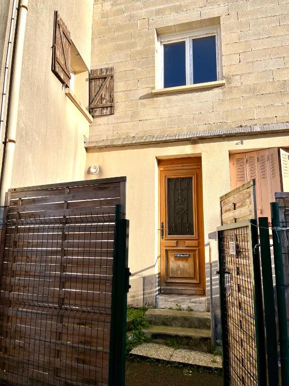 a house with a gate and a wooden door at Maison au Mesnil Amelot in Le Mesnil-Amelot