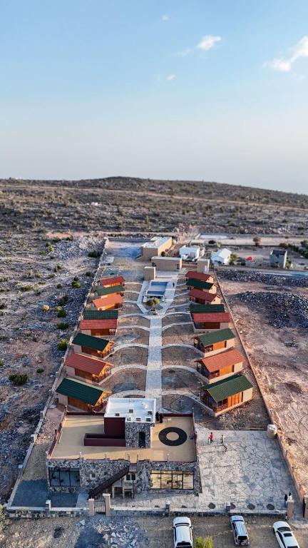 una vista aérea de un edificio con coches en un campo en Jabal Hatt Resthouse, en Khawr Zammah
