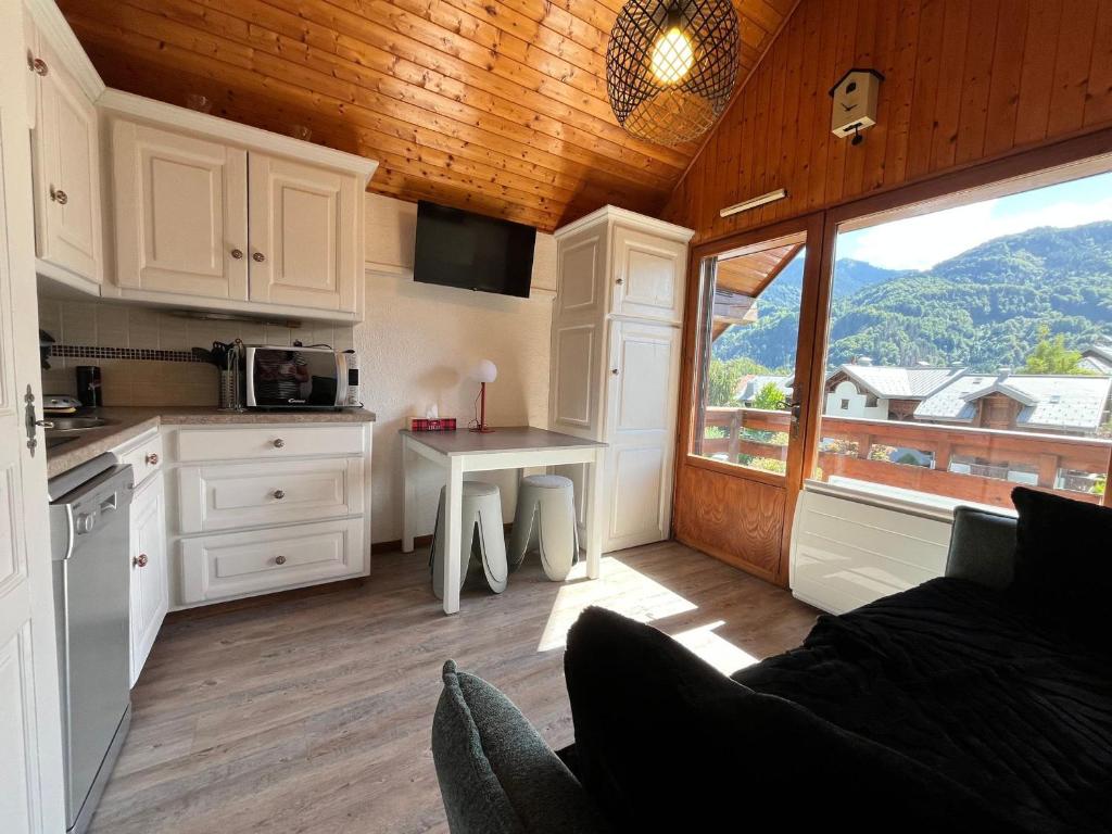 une cuisine avec une table et une cuisine avec une fenêtre dans l'établissement Studio cosy au centre de Samoëns avec balcon - FR-1-624-183, à Samoëns
