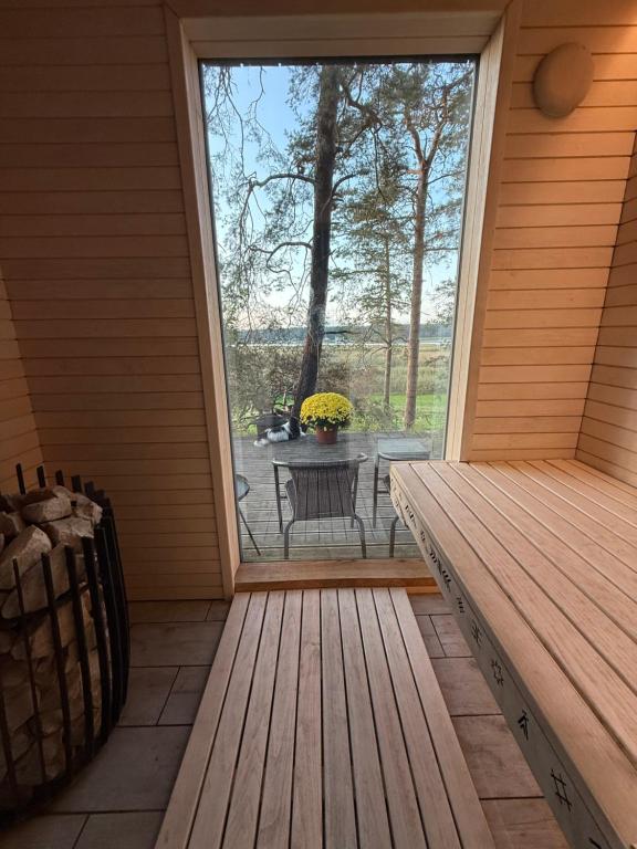 a screened in porch with a window and a table at Jahbazaar Hideout & Sauna in Jūrmala
