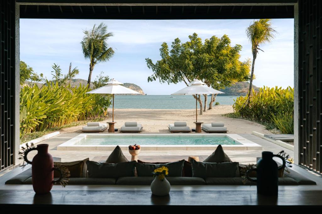a living room with a view of the beach at Kuara Lombok in Bumbang