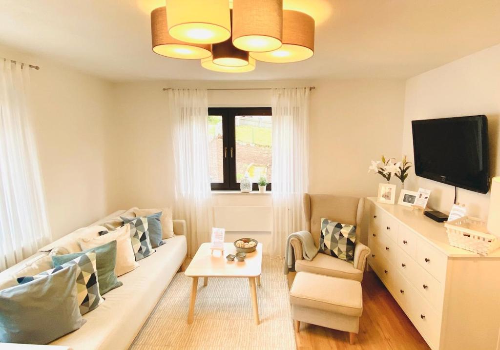 a living room with a couch and a tv at Ferienwohnung Marlene 80 Qm in Ebersburg