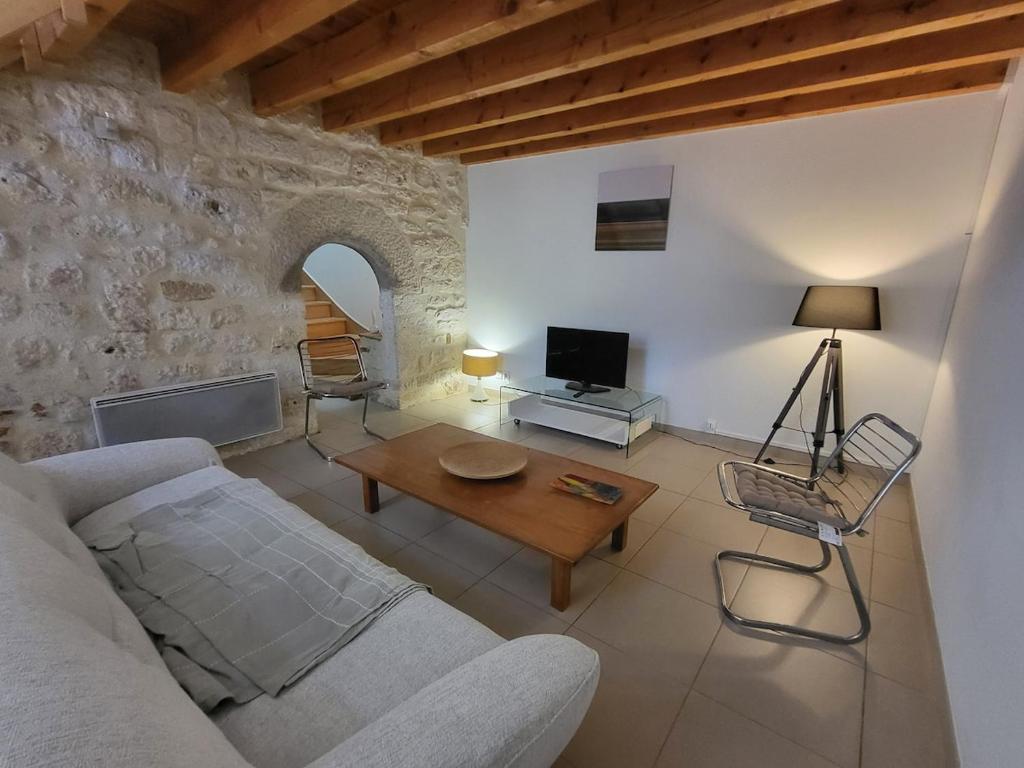 a living room with a couch and a table at Maison en pierre rénovée in Taïx