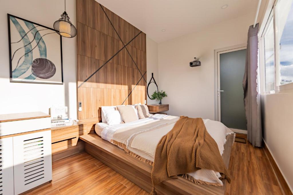 a bedroom with a bed with a wooden headboard at The Morris Boutique Hotel 2 - O'TEL in Da Lat