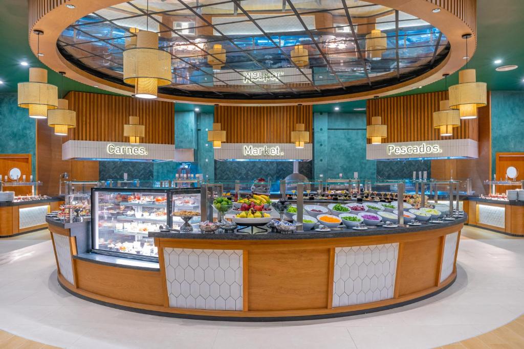 Large circular buffet area with multiple food stations, labeled sections, and hanging pendant lights.