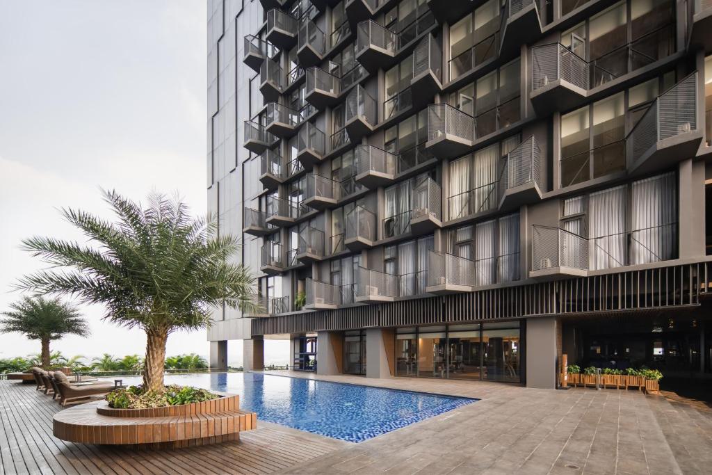 an exterior view of a building with a swimming pool at Cove Carstensz BSD in Kramat