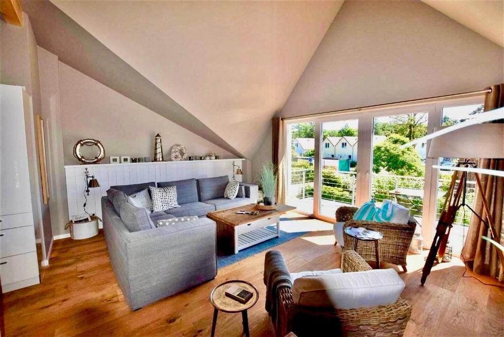 ein Wohnzimmer mit Sofa und Tisch in der Unterkunft Seesucht-Hohwacht - Grosse Ferienwohnung im Beachhouse-Stil, 2 Balkone, 2 SZ und nur 300m zum Strand in Hohwacht