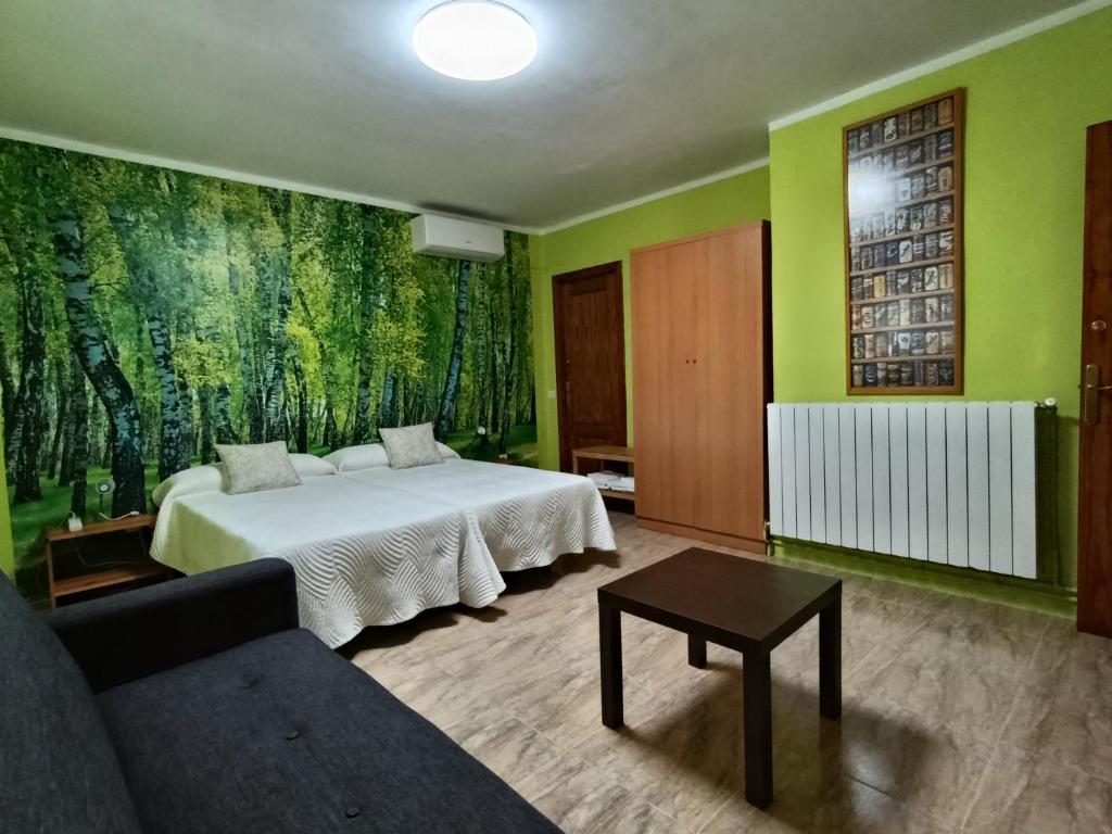 a bedroom with a bed and a couch and green walls at Casa Rural Natalia in Valmuel